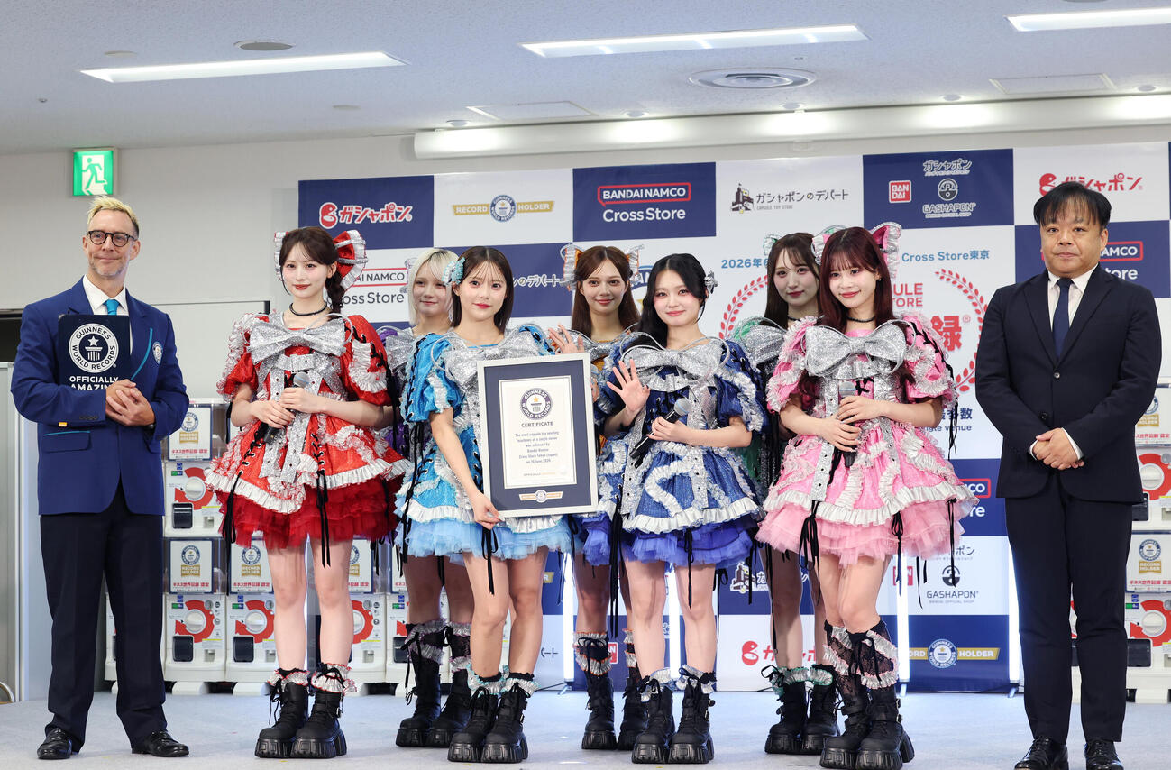 「バンダイナムコ　Cross Stroe　東京」内カプセルトイ専門店　ギネス認定　挑戦PRイベンで認定パネルを手に笑顔を見せる左から公式認定員ジャスティン・パターソンさん、CANDY TUNE、株式会社バイダイナムコエクスペリエンス吉田和誠ゼネラルマネージャー（撮影・増田悦実）