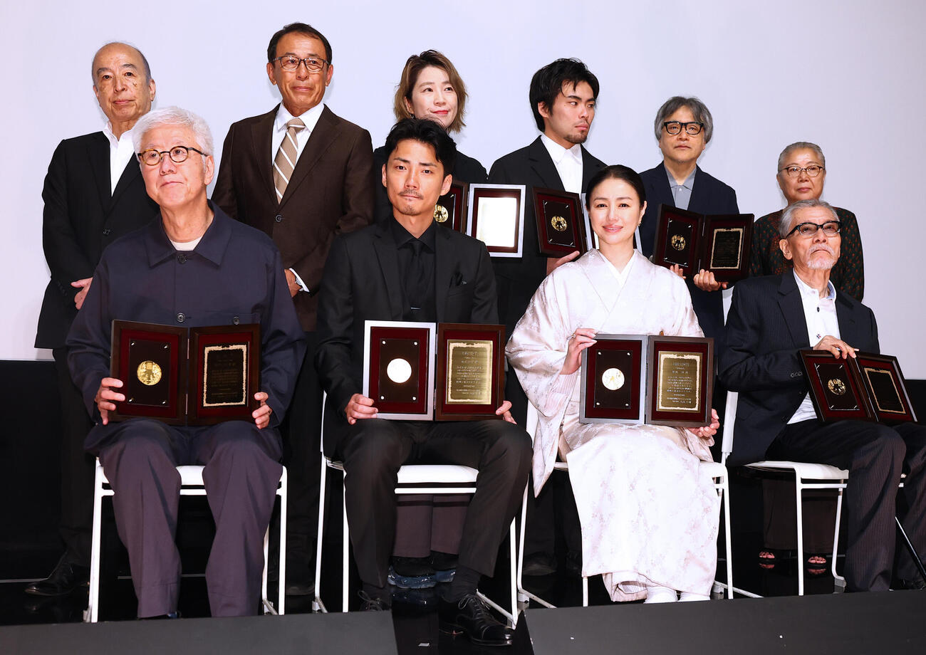 第35回日本映画プロフェッショナル大賞の受賞者。前列左から、監督賞の根岸吉太郎監督、主演男優賞の毎熊克哉、主演女優賞の井川遥、特別功労賞の塩見三省、後列左から、実行委員長の大高宏雄氏、作品賞の「桐島です」製作総指揮の長尾和宏氏、脚本の梶原阿貴氏、新人監督賞の団塚唯我監督、特別賞の「アジアのユニークな国」製作チーム、山内ケンジ監督、野上信子プロデューサー（撮影・野上伸悟）