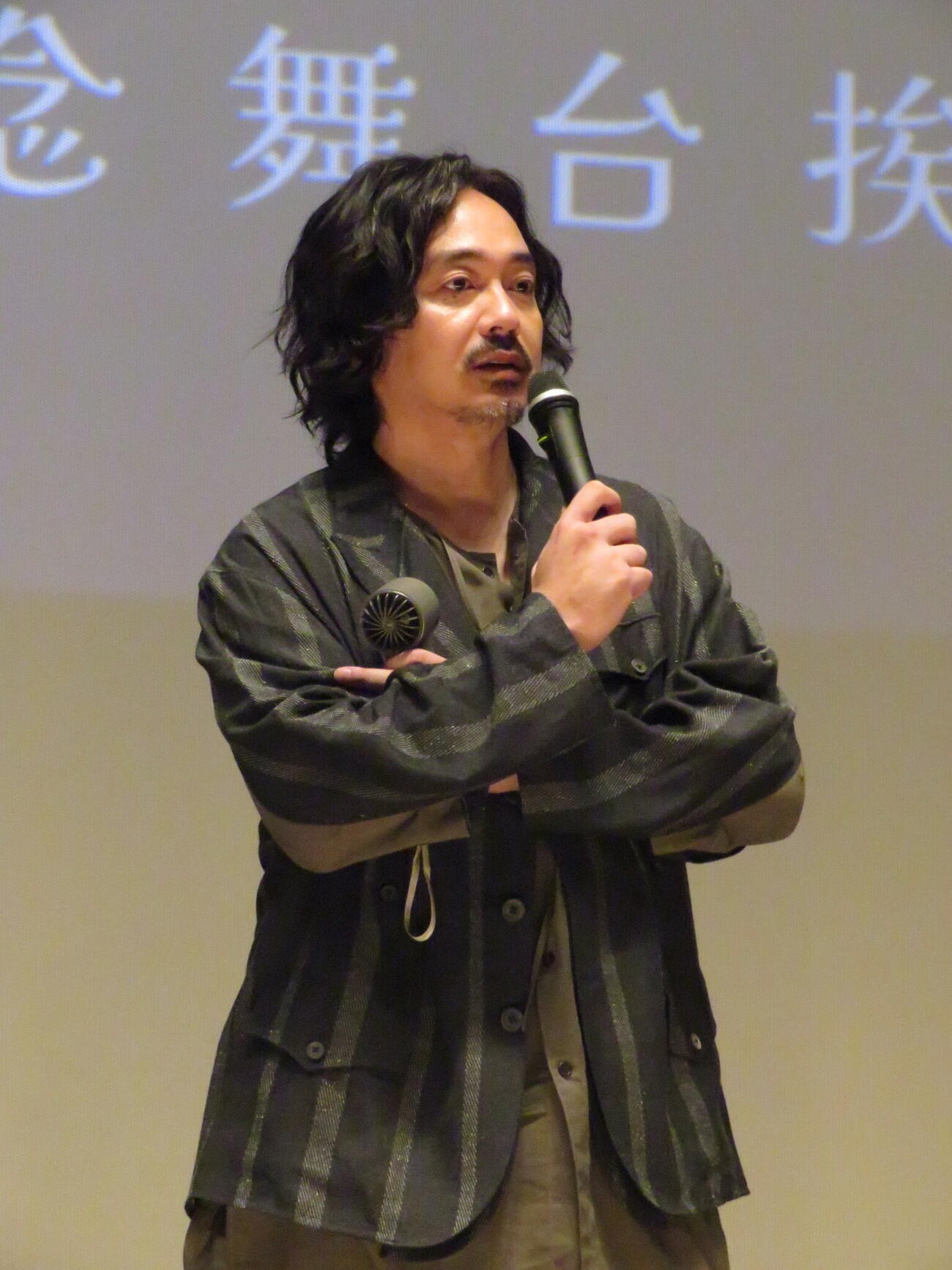 右手にマイク、左手にハンディ扇風機を手に、映画「ディッシュアップ」の舞台あいさつを行った青柳翔