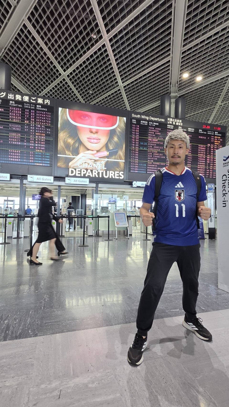 米ダラスでのスウェーデン戦での現地応援に向け、成田空港を出発するFW前田大然をマネる「前田大自然」を名乗るタクシー運転手の藤本亮さんはガッツポーズで気合いを入れた
