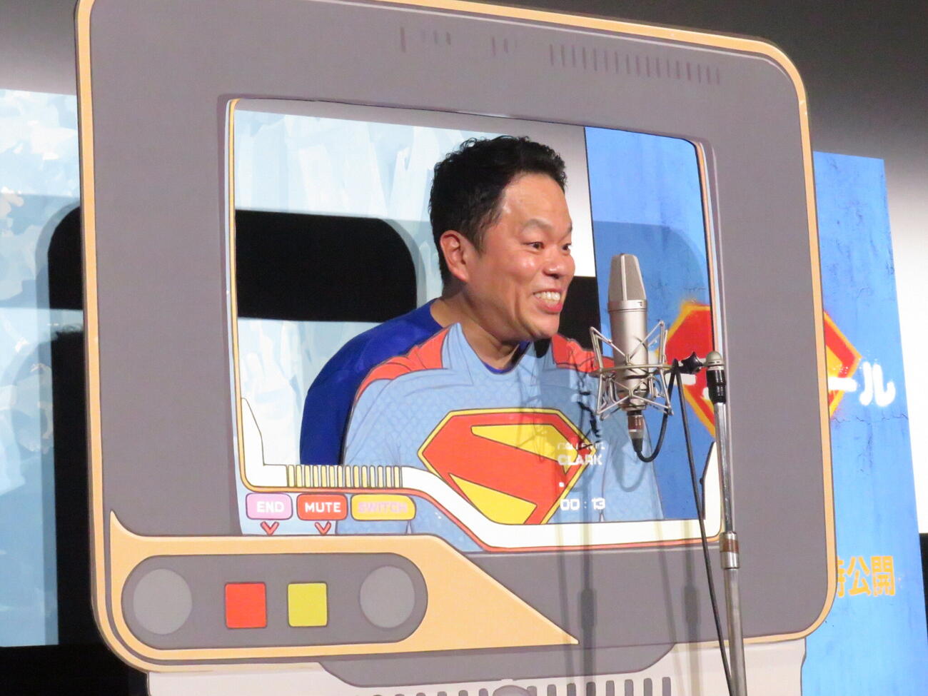 映画「スーパーガール」の特別試写イベントで、スーパーマンの顔ハメパネルに顔をセットしてアフレコしたダイアンの津田篤宏