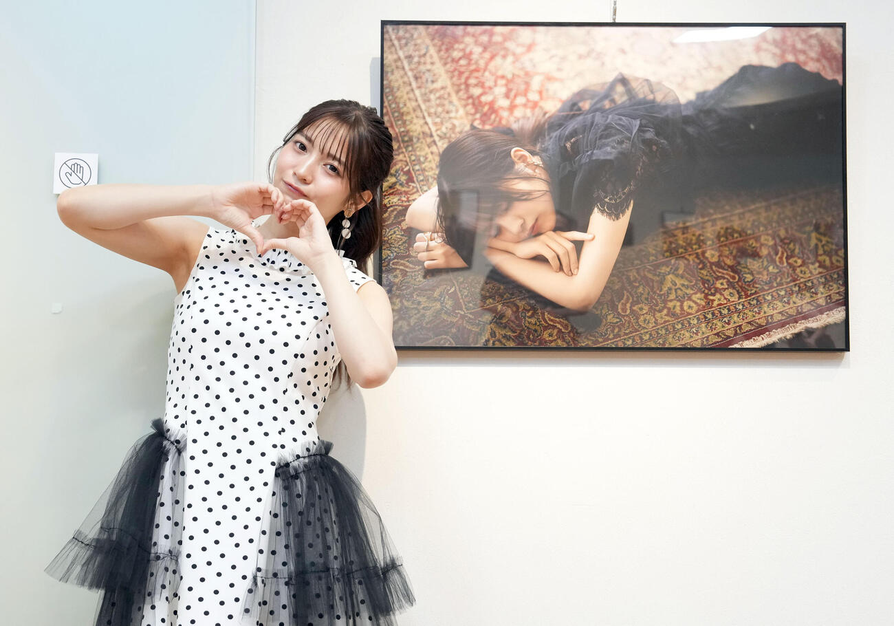 初写真展を開催する黒嵜菜々子は、作品の前でポーズを決める（撮影・たえ見朱実）