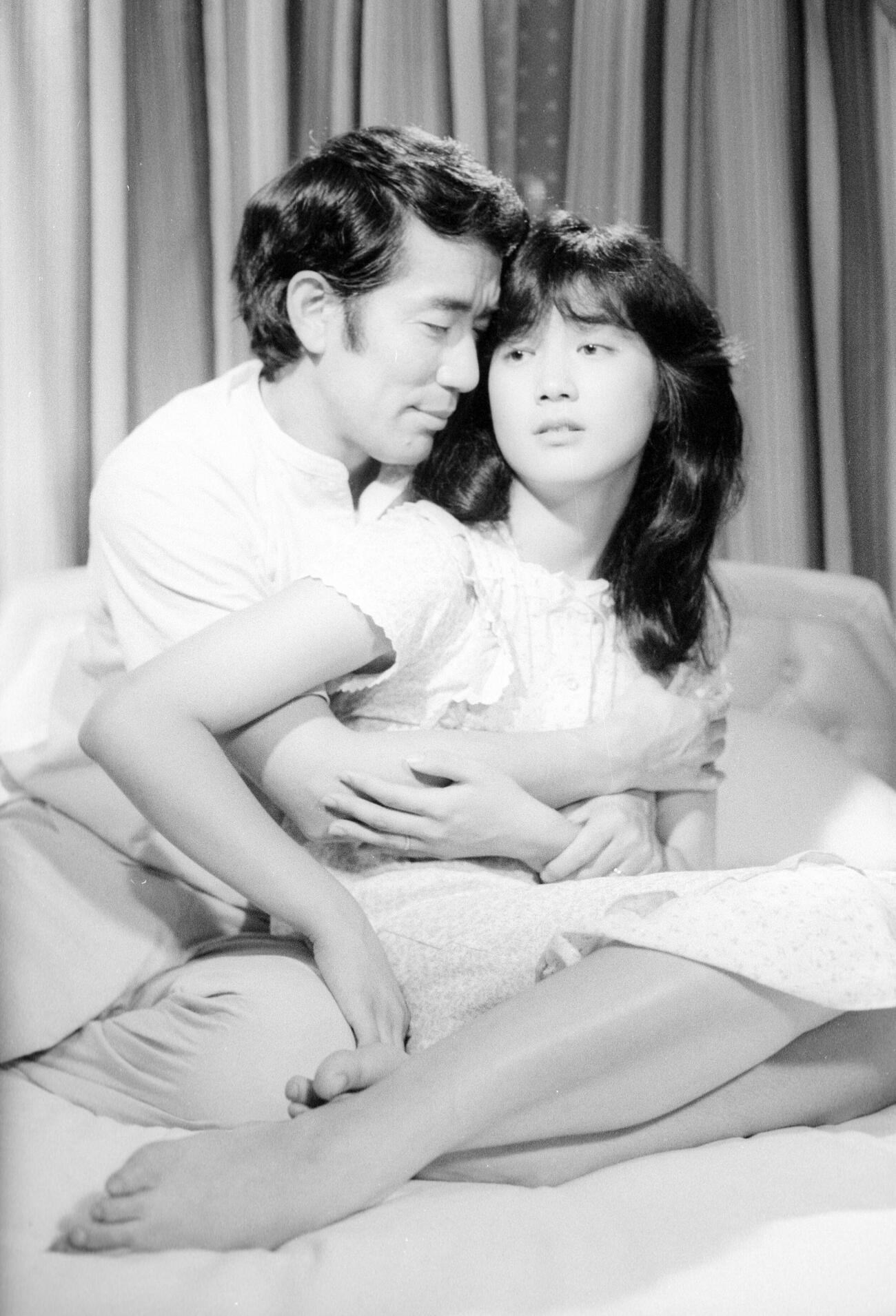 テレビ朝日「おさな妻私を抱いて…16歳の初夜」でベテラン中村敦夫相手に大胆なラブシーンを演じる現役女子高生の安田成美（1983年7月撮影）