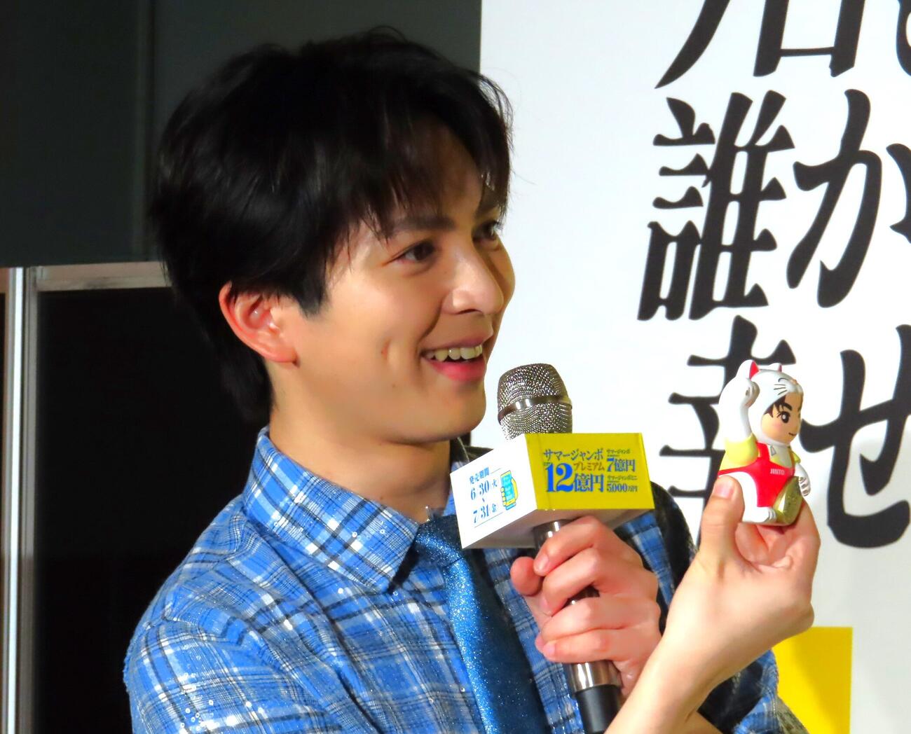 「サマージャンボプレミアム」「サマージャンボ宝くじ」「サマージャンボミニ」発売記念イベントで、自身の顔が描かれた招き猫を手にする吉田仁人