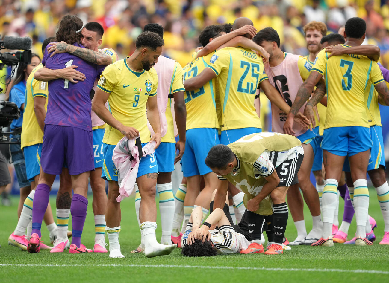 日本対ブラジル　試合後、倒れ込む田中碧（下）に声をかける長友佑都。左はブラジルのクニャ（撮影・足立雅史）