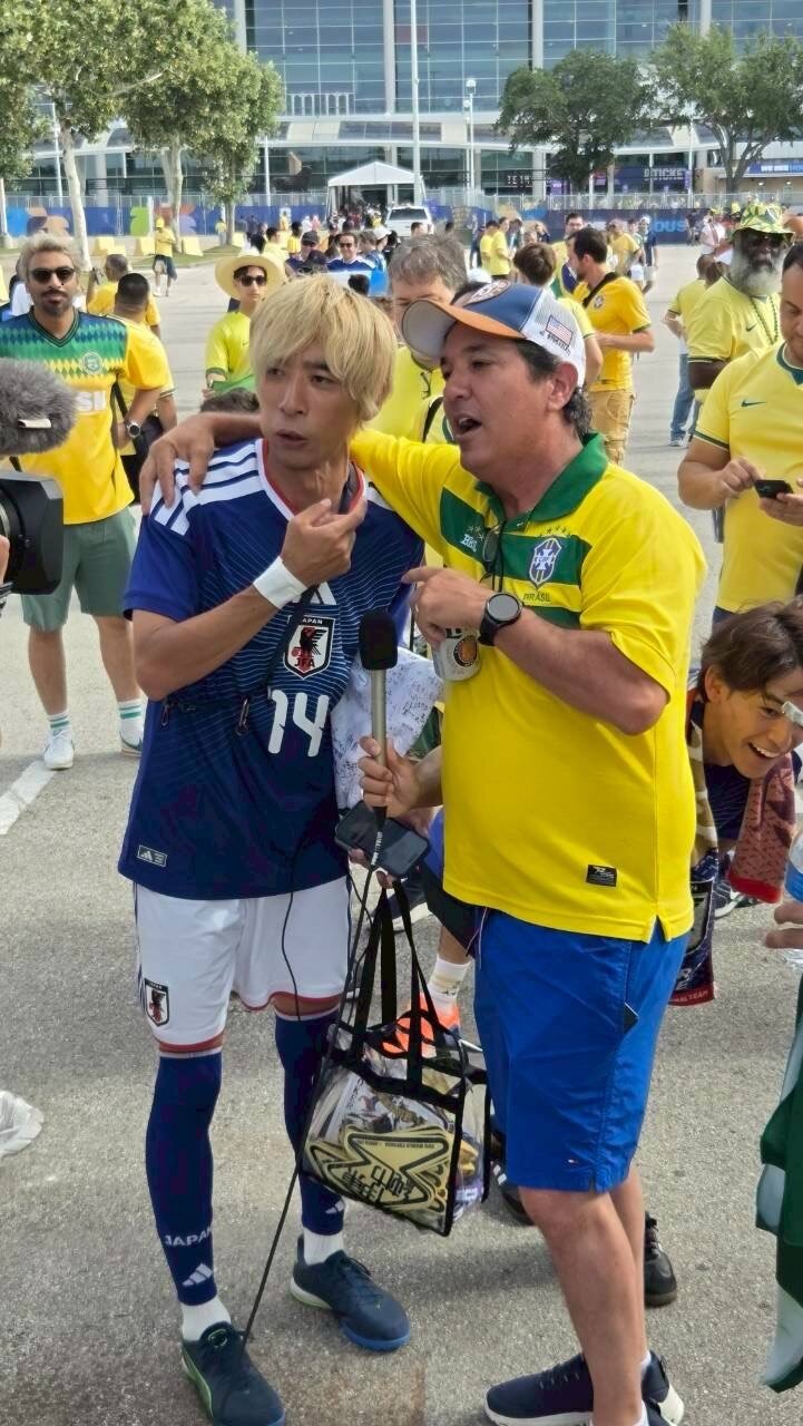 ブラジル戦の行われるヒューストンの試合会場で、サッカー日本代表のそっくり芸人グループ「ものまねブルー」の似東JOKER純也（左）はブラジルのテレビ局クルーに突撃取材を受けてタジタジ