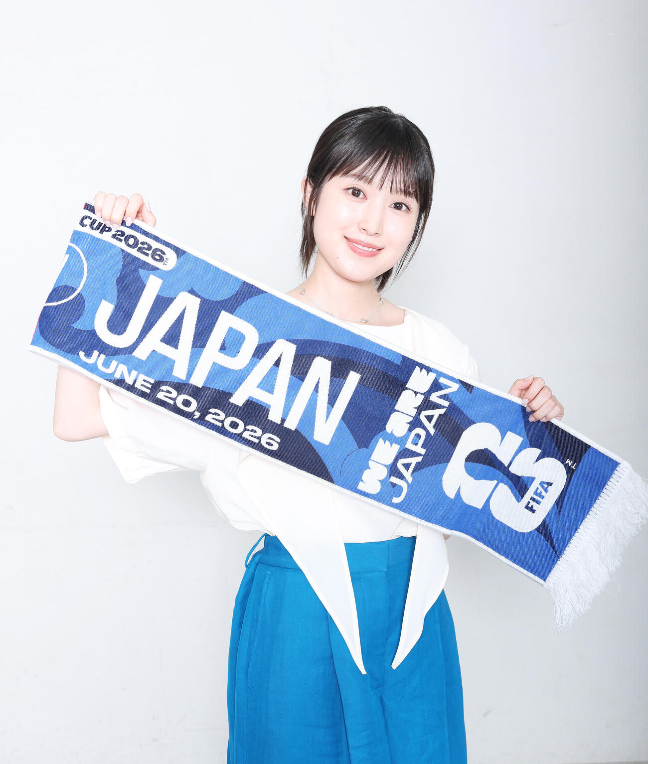 現地で購入した応援タオルを手に笑顔を見せる福本莉子（2026年6月撮影）