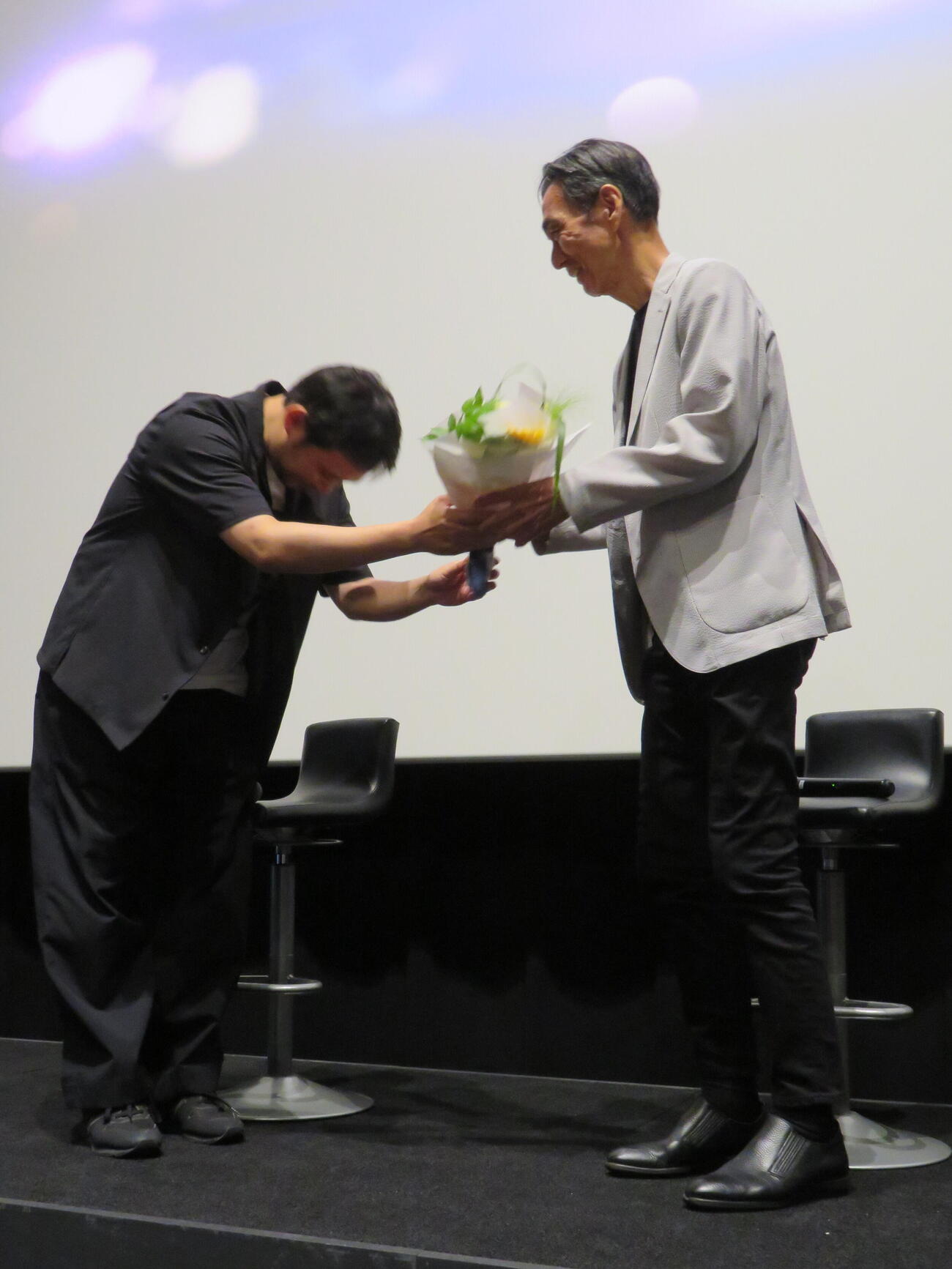 「急に具合が悪くなる」公開記念トークイベントで濱口竜介監督（左）から花束を贈られる長塚京三（撮影・村上幸将）