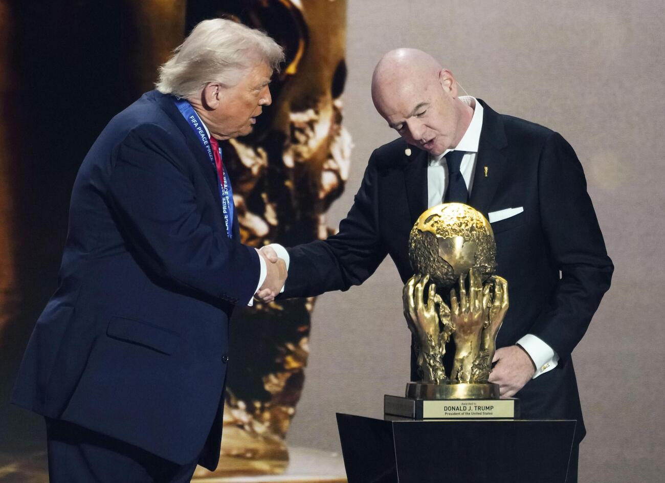 サッカーW杯北中米3カ国大会の組み合わせ抽選会で、トランプ米大統領（左）に「FIFA平和賞」を授与するインファンティノ会長＝2025年12月、米ワシントン（共同）