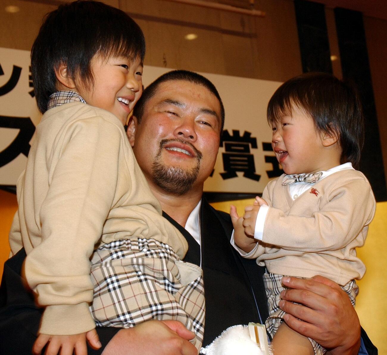 健之介君（左）、誠之介君を抱きかかえ、笑顔をみせる佐々木健介（2004年12月撮影）