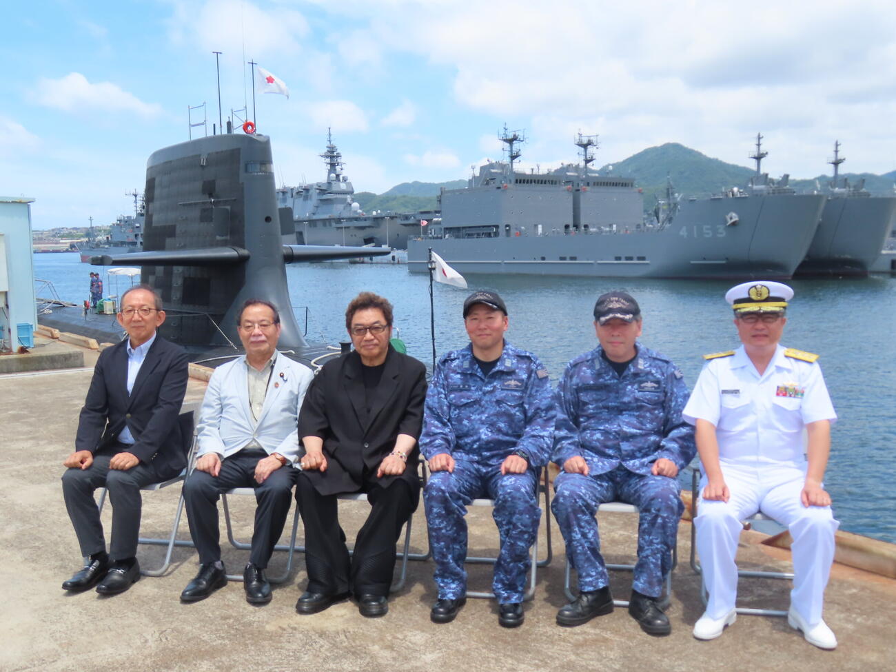 呉港で潜水艦を後ろに記念撮影するコロッケ（左から3人目）