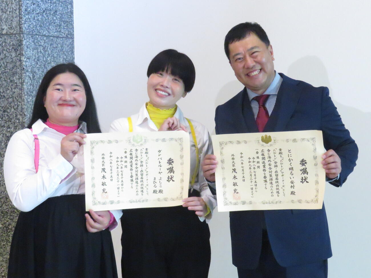 「『たびレジ』サポーターズ」の委嘱状を手に笑顔を見せる、とにかく明るい安村（右）、「ガンバレルーヤ」よしこ（左）、まひる