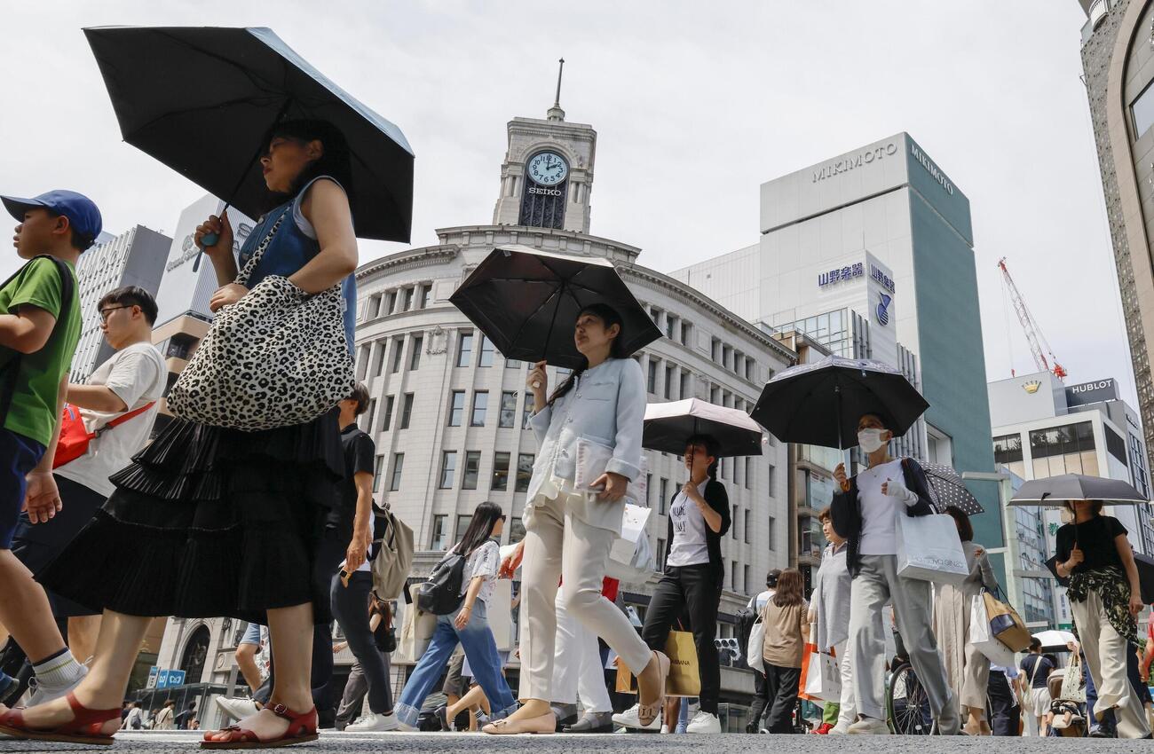 東京・銀座を日傘を差して歩く人たち＝14日午後(共同)