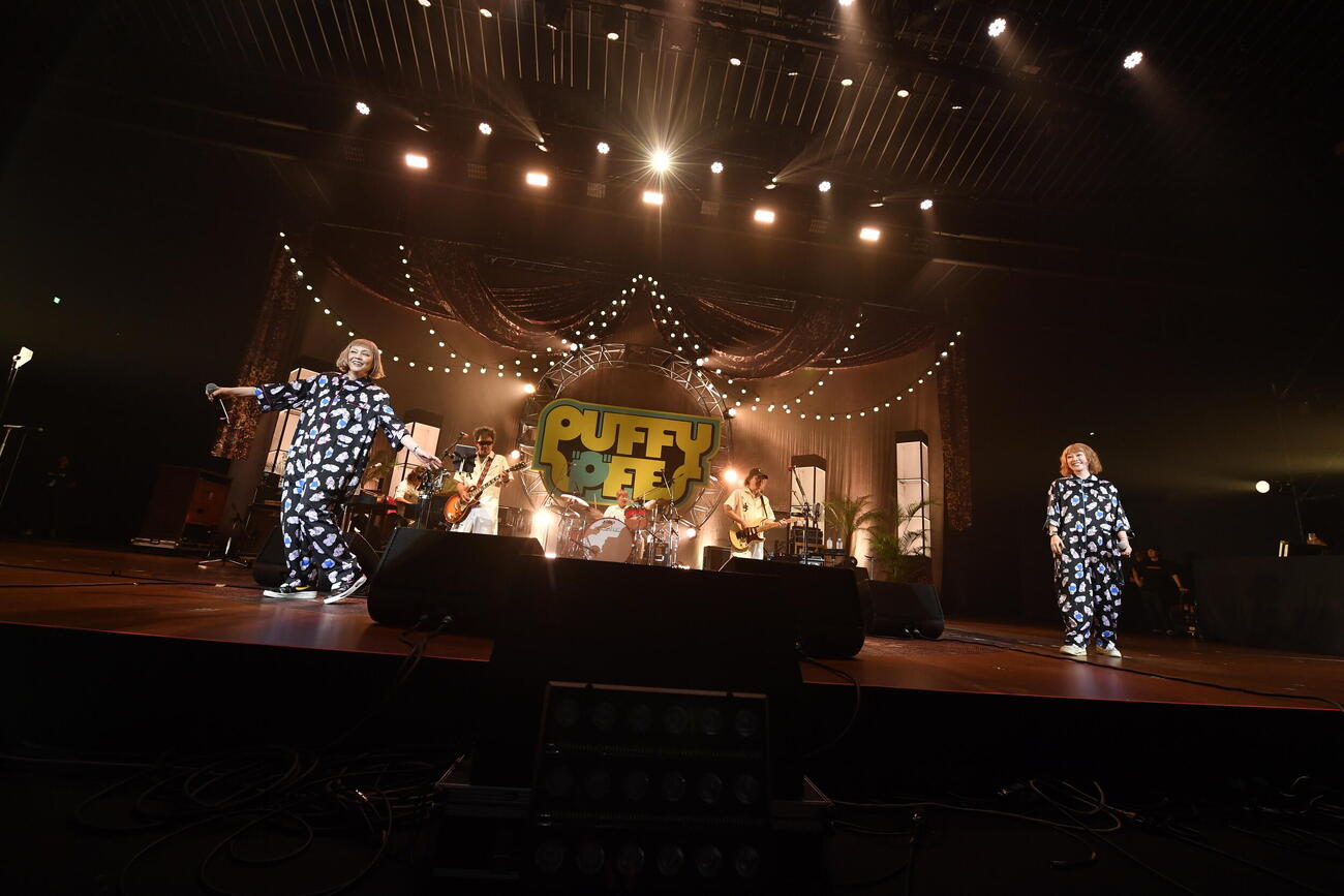 「PUFFYの”P”FES」でパフォーマンスする吉村由美（左）と大貫亜美と、演奏するUNICORN（奥）（三浦憲治撮影）