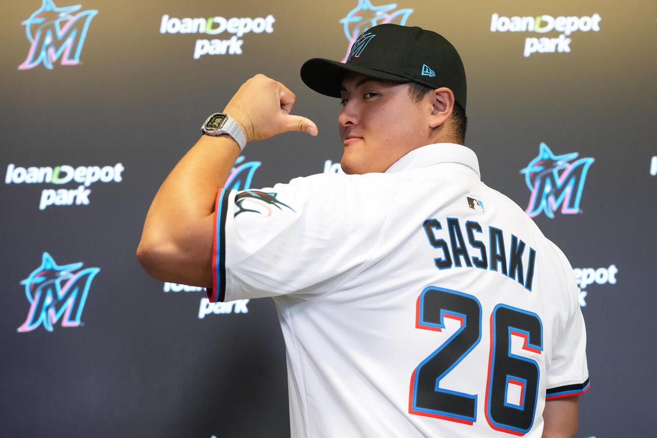 入団会見で背番号を見せるマーリンズ佐々木麟太郎（AP）