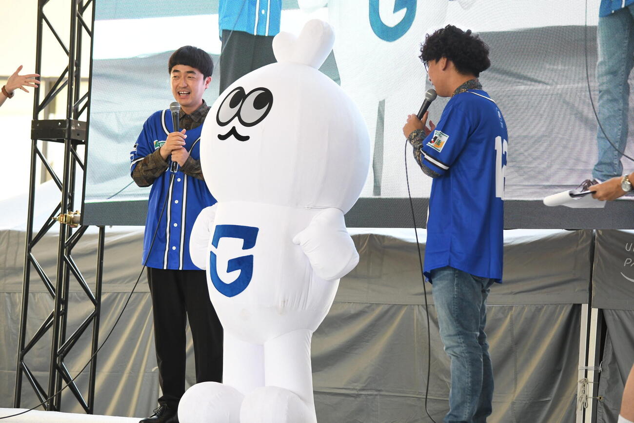 「GAMBA OSAKA KICKOFF FES」に出演した、左から、たくろうの赤木裕、ガンバ大阪公式マスコットHARCHIMO、たくろうのきむらバンド（撮影・阪口孝志）