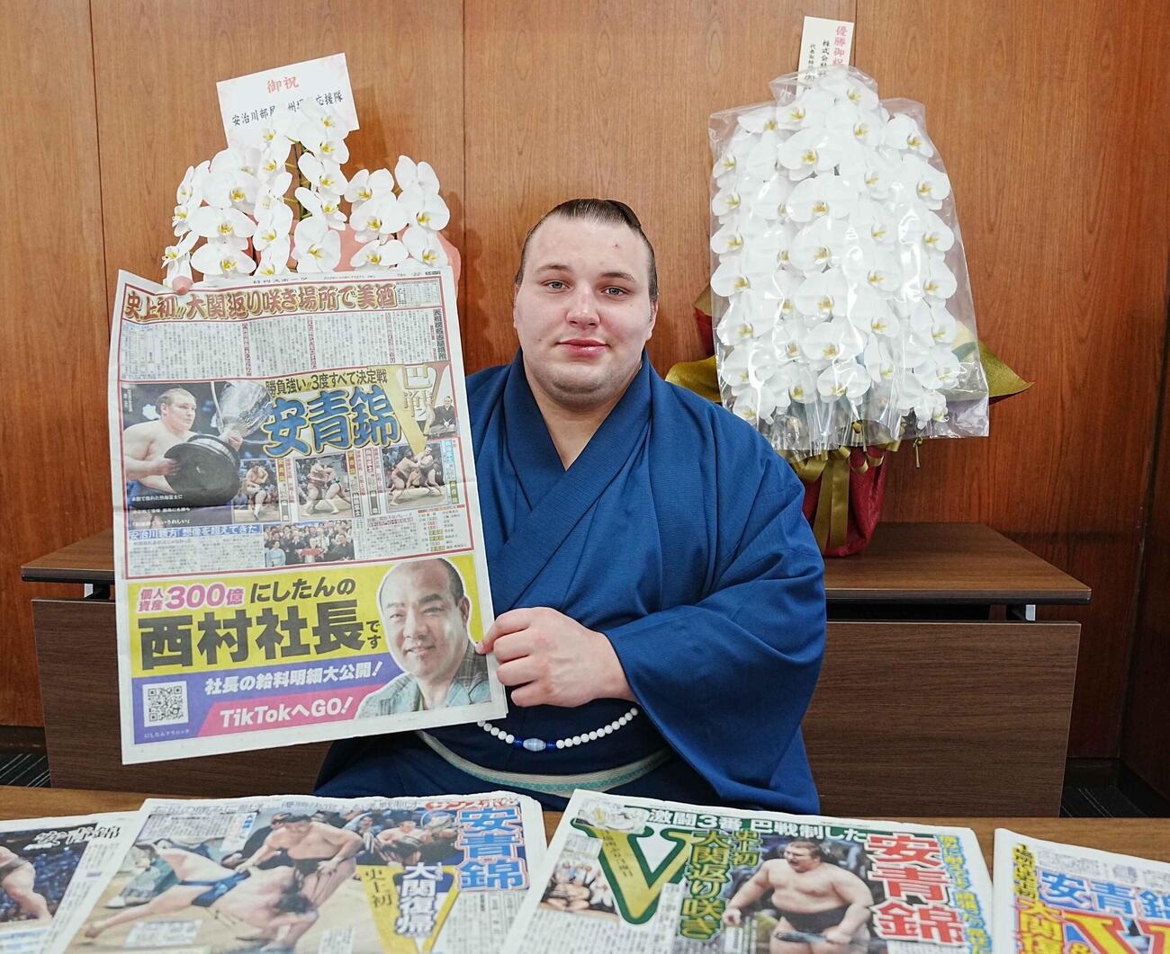 優勝一夜明け会見で快挙を報じた日刊スポーツを手にする安青錦（撮影・小沢裕）