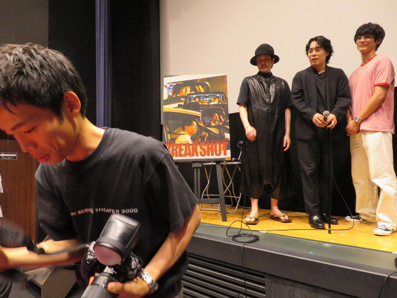 短編映画「BREAK SHOT」劇場公開記念トークイベントで、オフィシャルカメラマンとしてオダギリジョー、くるま、高良健吾を撮影する、かか゛屋の加賀翔（左）（撮影・村上幸将）
