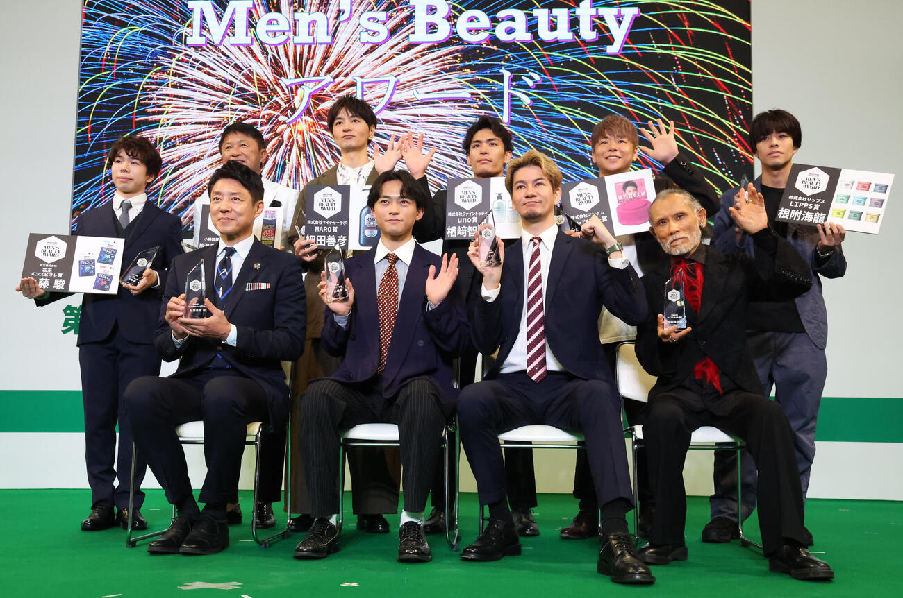 第6回Men's BeautyアワードでTVカメラに向かって手を振る受賞者の、前列左から松岡修造、中山翔貴、JOY、片岡鶴太郎。後列左から佐藤駿、武田修宏、細田善彦、楢崎智亜、武尊、根附海龍（撮影・丹羽敏通）