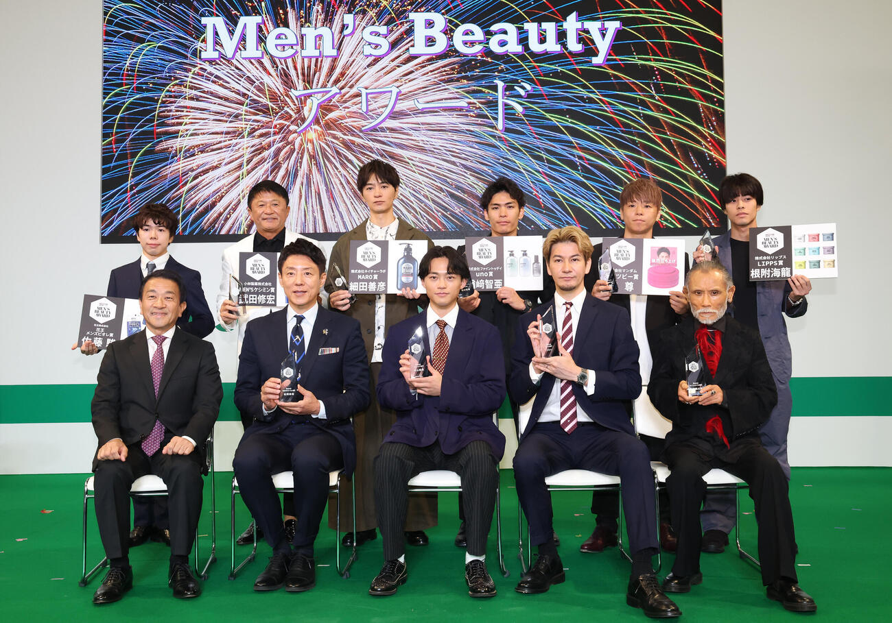 第6回Men's Beautyアワードで写真に納まる、前列左から日本チェーンドラッグストア協会会長の塚本厚志氏、松岡修造、中山翔貴、JOY、片岡鶴太郎。後列左から佐藤駿、武田修宏、細田義彦、楢崎智亜、武尊、根附海龍（撮影・丹羽敏通）