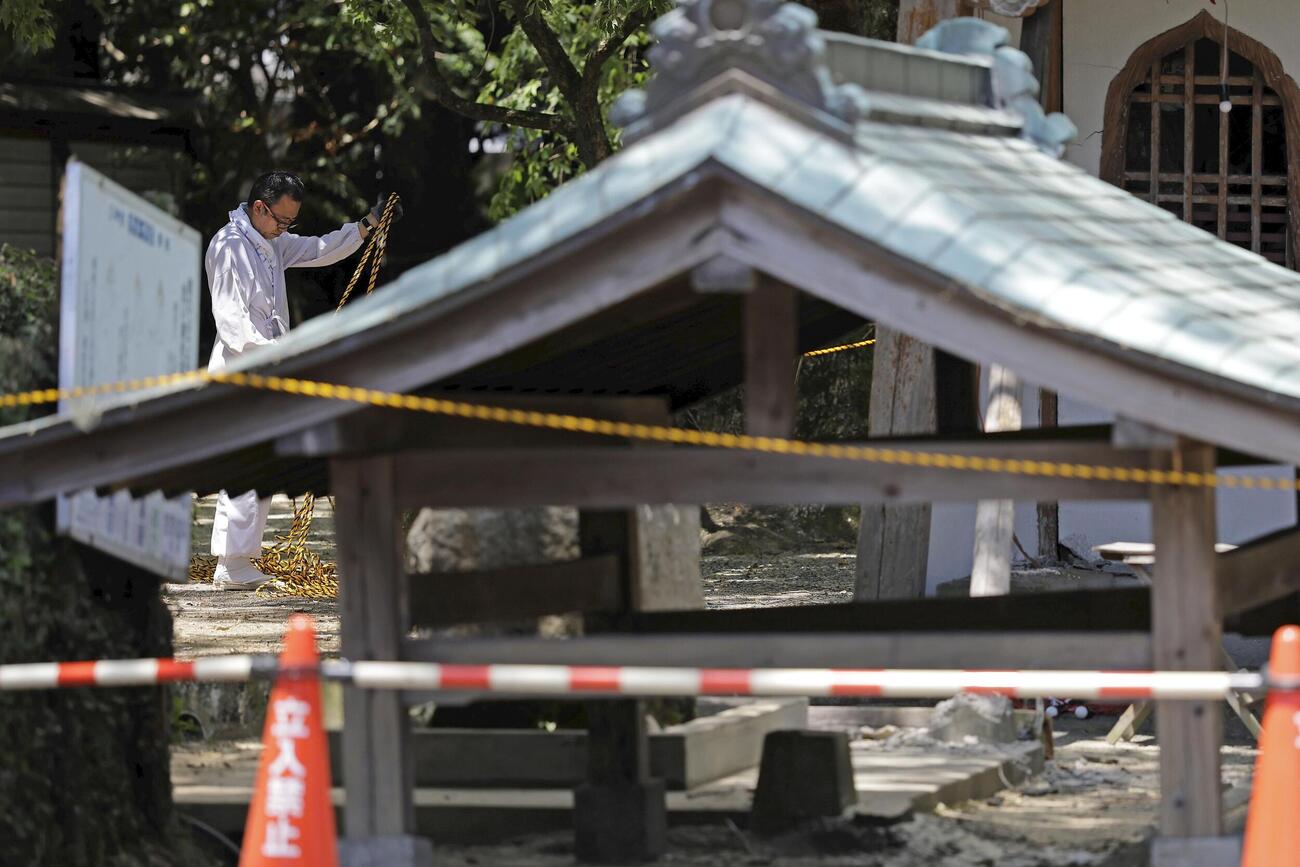 片付け作業をする宮原三神宮の神主＝31日午後0時59分、熊本県氷川町（共同）