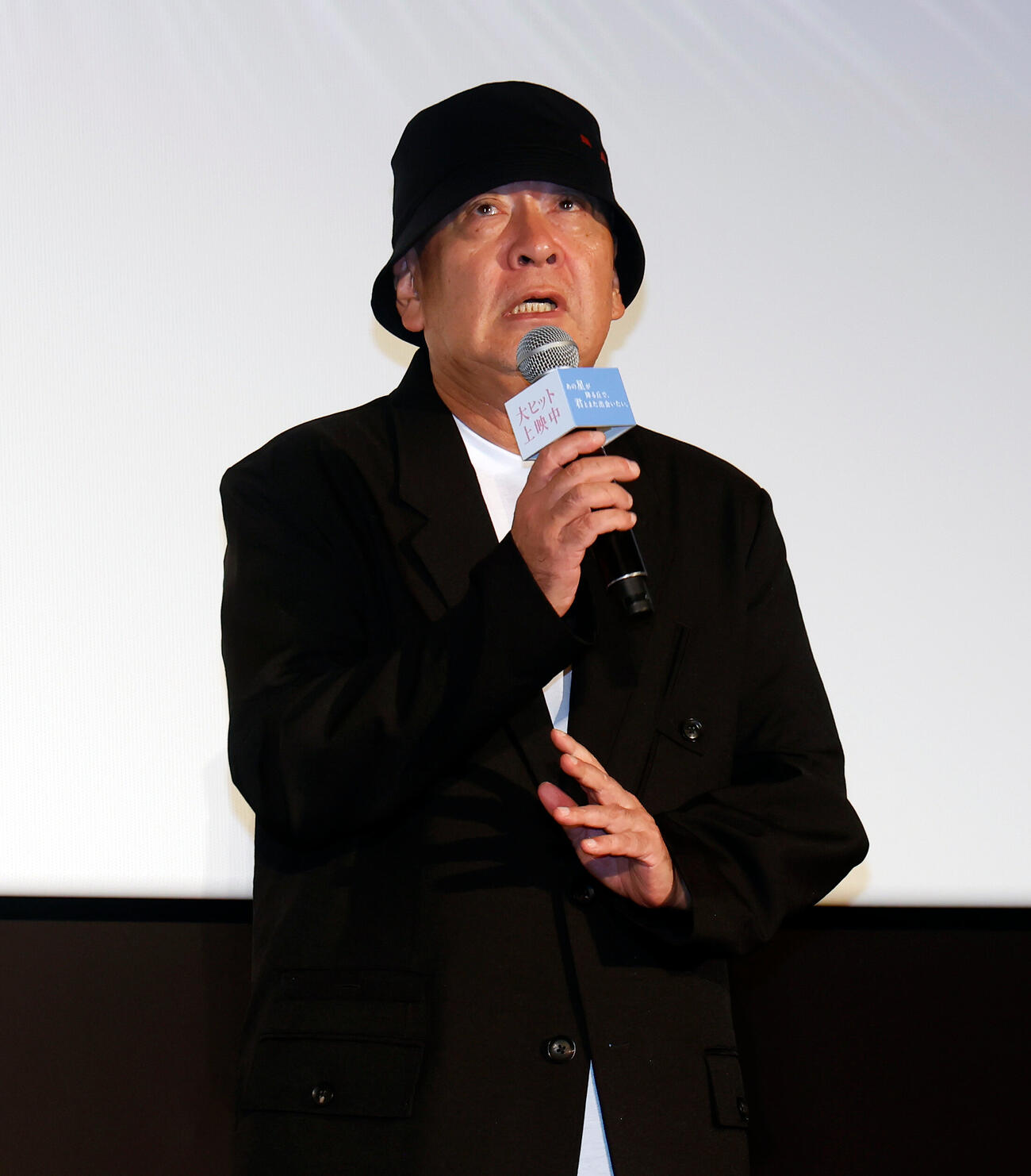 登壇し、あいさつをする新城毅彦監督（撮影・山本朝陽）