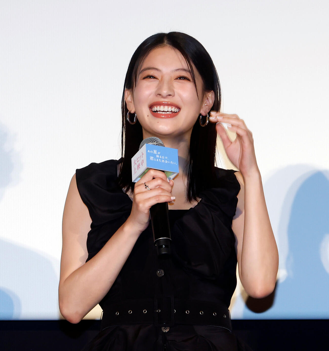 登壇し、笑顔を見せる出口夏希（撮影・山本朝陽）