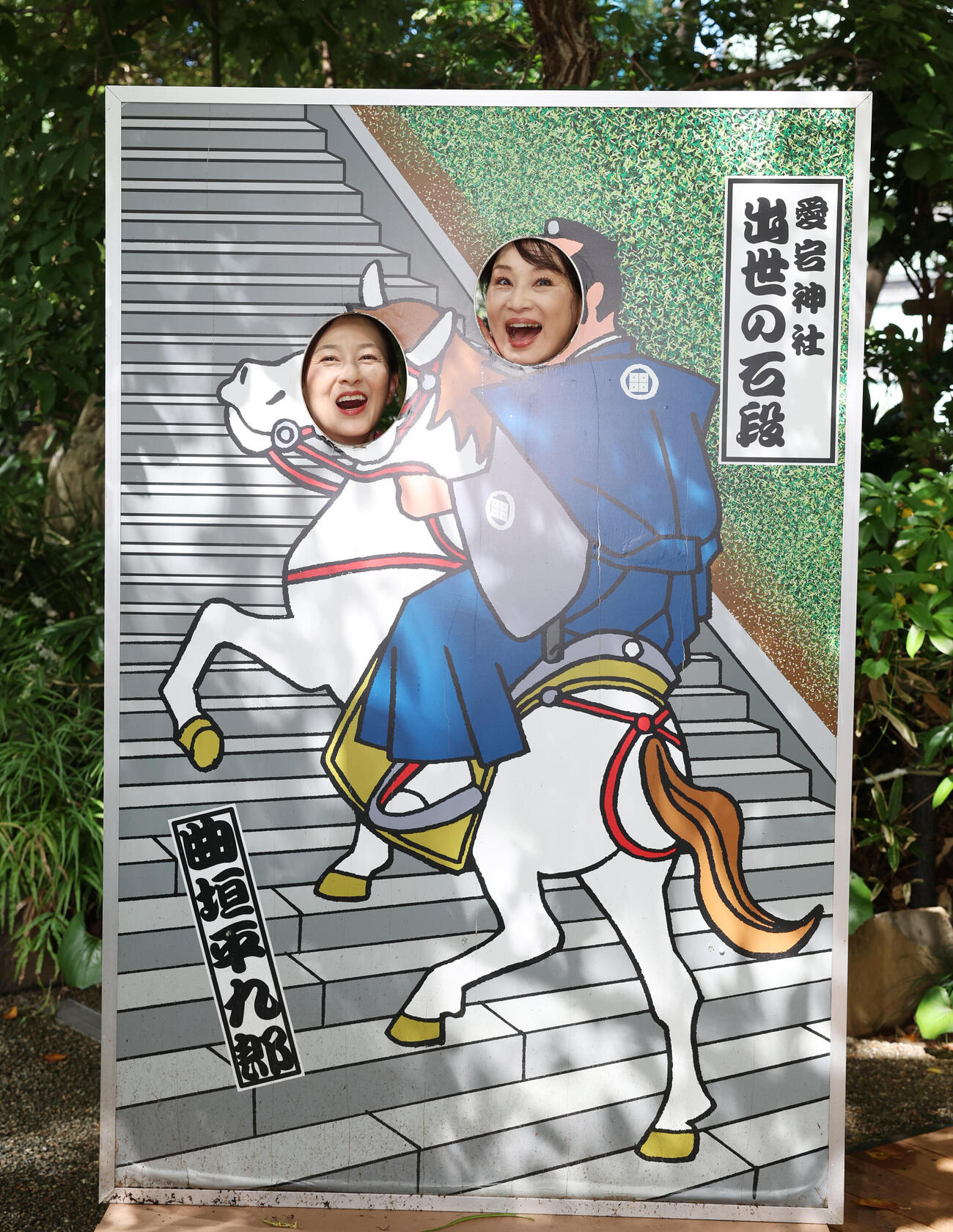 愛宕神社の顔ハメパネルに顔をはめ、笑顔を見せる森尾由美（左）と小林千絵（撮影・増田悦実）