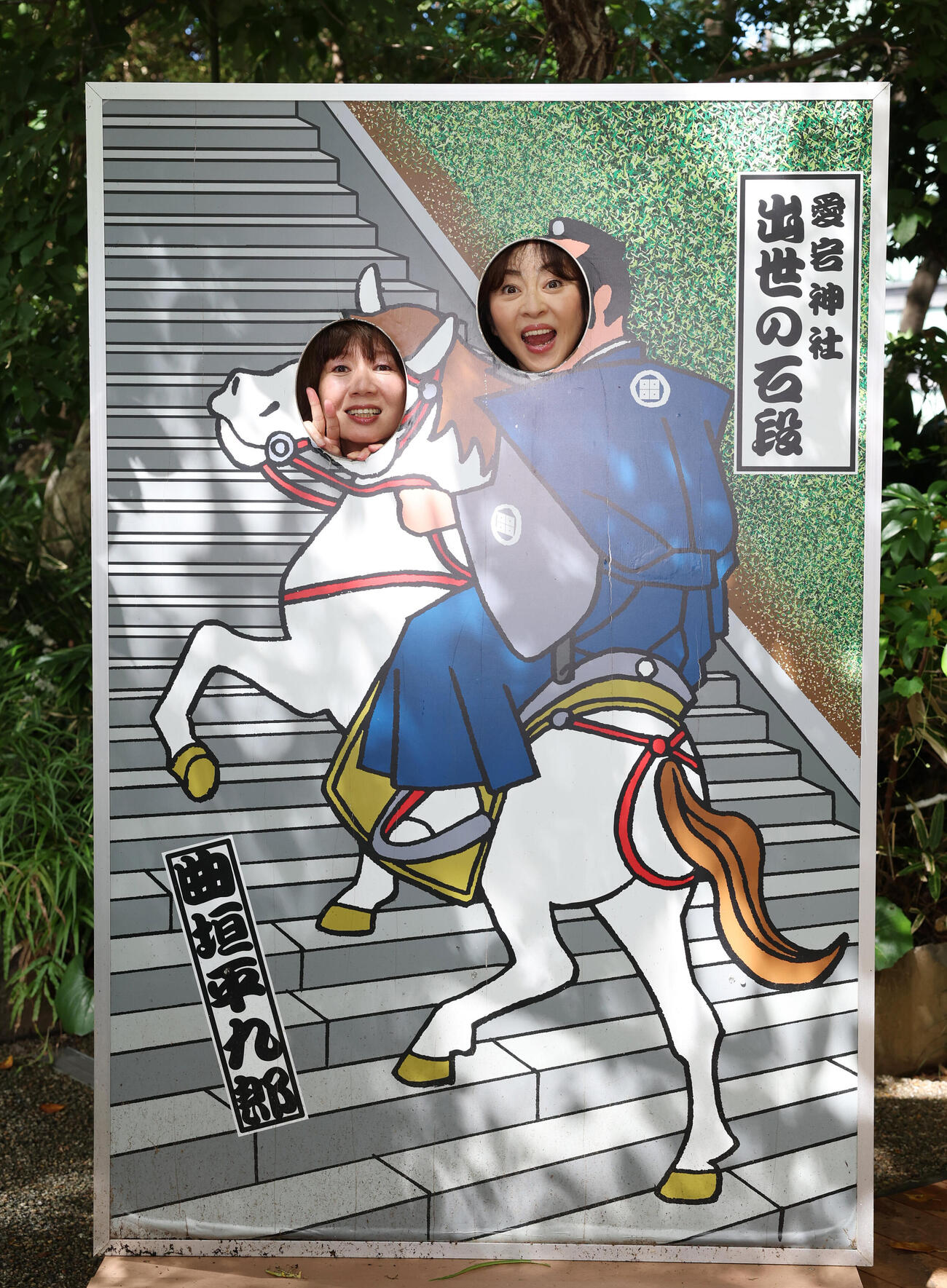 愛宕神社の顔ハメパネルに顔をはめ、笑顔を見せる桑田靖子（左）と松本明子（撮影・増田悦実）