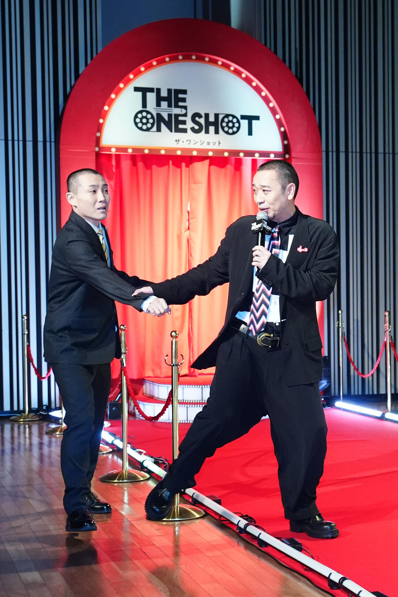 ディズニープラス発のオリジナルバラエティー番組「THE ONE SHOT」ワールドプレミアで登場したランジャタイの国崎和也（左）を壇上に連れていく千鳥の大悟（撮影・江口和貴）