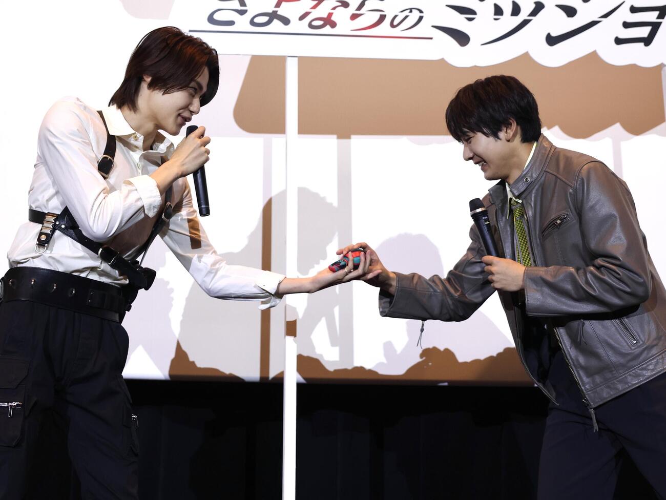 「仮面ライダーゼッツ」＆「仮面ライダーマイス」バトンタッチイベントで今井竜太郎（左）に私物の仮面ライダーゼッツのぬいぐるみを預ける秋谷郁甫（撮影・宮地輝）