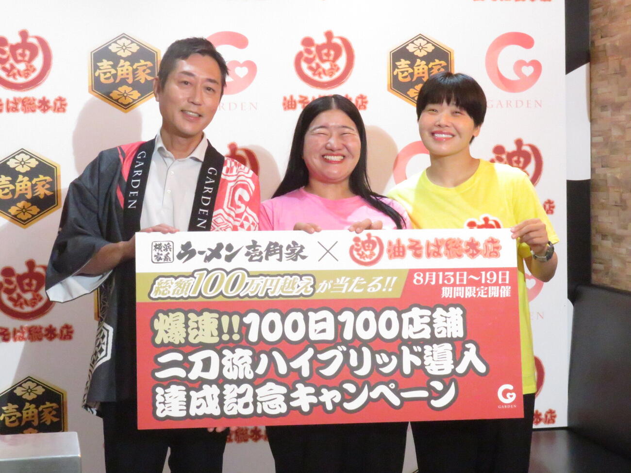「壱角家×油そば総本店『爆速！！　100日100店舗二刀流ハイブリッド導入達成記念キャンペーン』発表会」に参加したガンバレルーヤのよしこ（中央）とまひる（右）。左は株式会社ガーデンの川島賢社長
