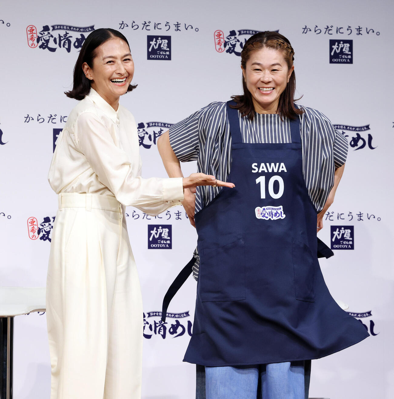 大戸屋「愛情めし」販売記念発表会で澤穂希さん（右）にエプロンを贈呈する亜希（撮影・宮地輝）