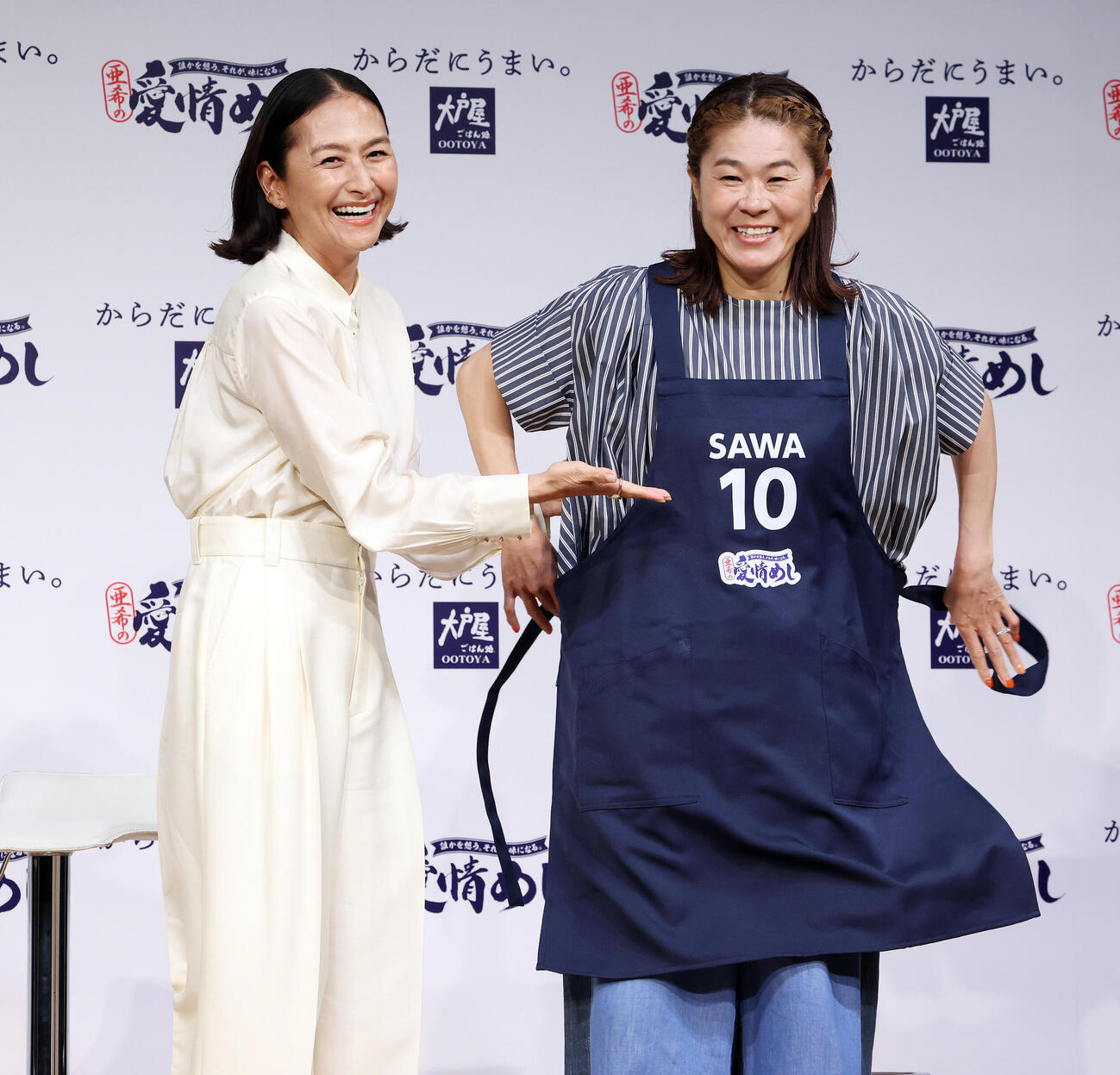 大戸屋「愛情めし」販売記念発表会で澤穂希さん（右）にエプロンを贈呈する亜希（撮影・宮地輝）