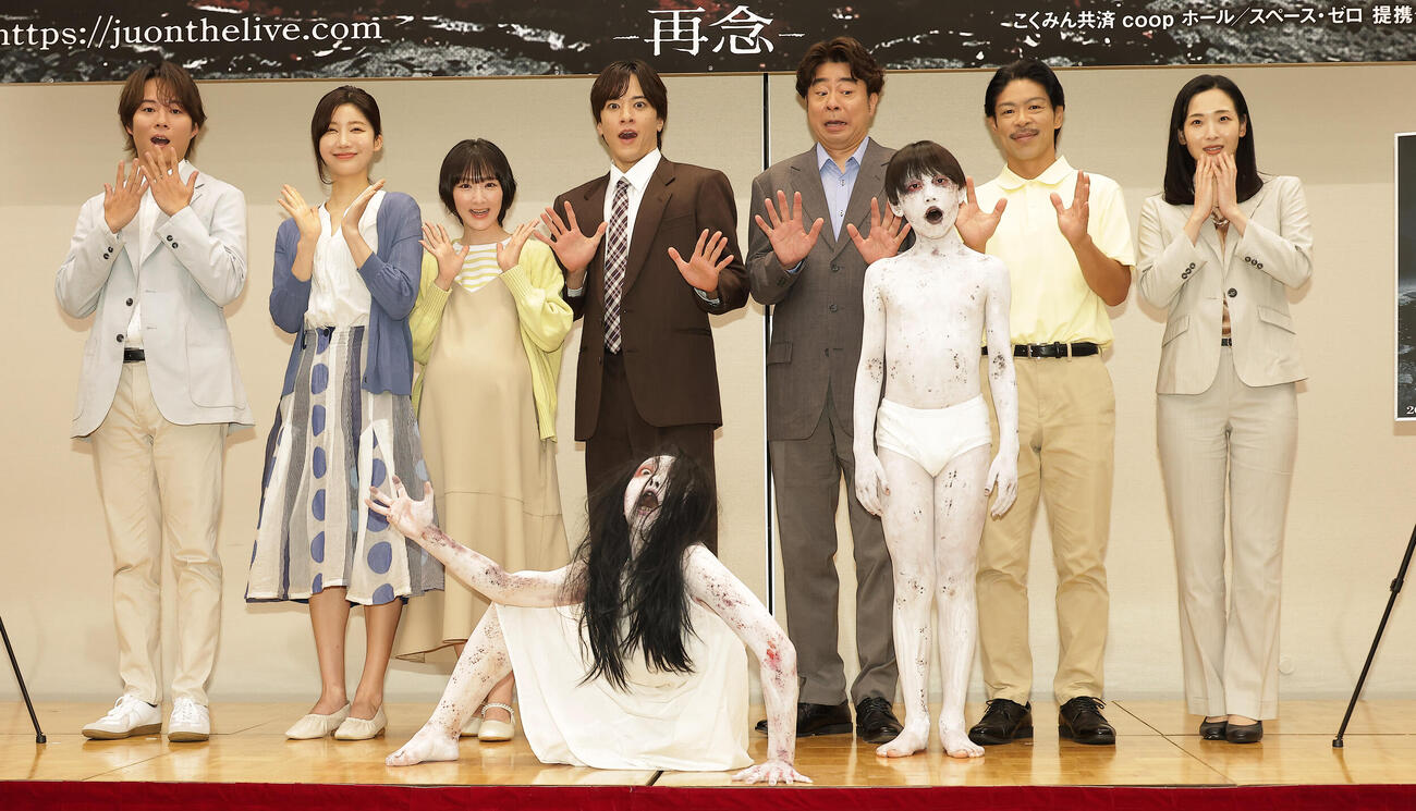 舞台「呪怨」製作発表会見でキャラクターの佐伯伽椰子（手前左）と息子の俊雄（手前右）を迎え記念撮影するキャスト、左から杉本琢弥、小倉ゆうか、生駒里奈、松島庄汰、有野晋哉、松本利夫、蘭乃はな（撮影・中島郁夫）.