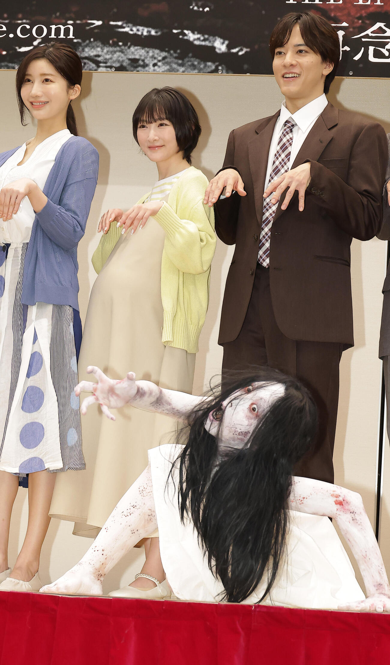 キャラクターの佐伯伽椰子（手前）を迎え記念撮影する、左から小倉ゆうか、生駒里奈、松島庄汰（撮影・中島郁夫）
