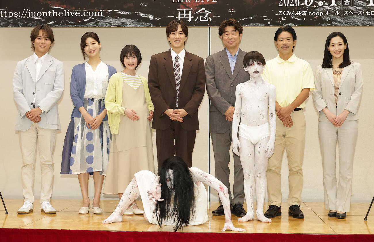舞台「呪怨」製作発表会見でキャラクターの佐伯伽椰子（手前左）と息子の俊雄（手前右）を迎え記念撮影するキャスト、左から杉本琢弥、小倉ゆうか、生駒里奈、松島庄汰、有野晋哉、松本利夫、蘭乃はな（撮影・中島郁夫）.