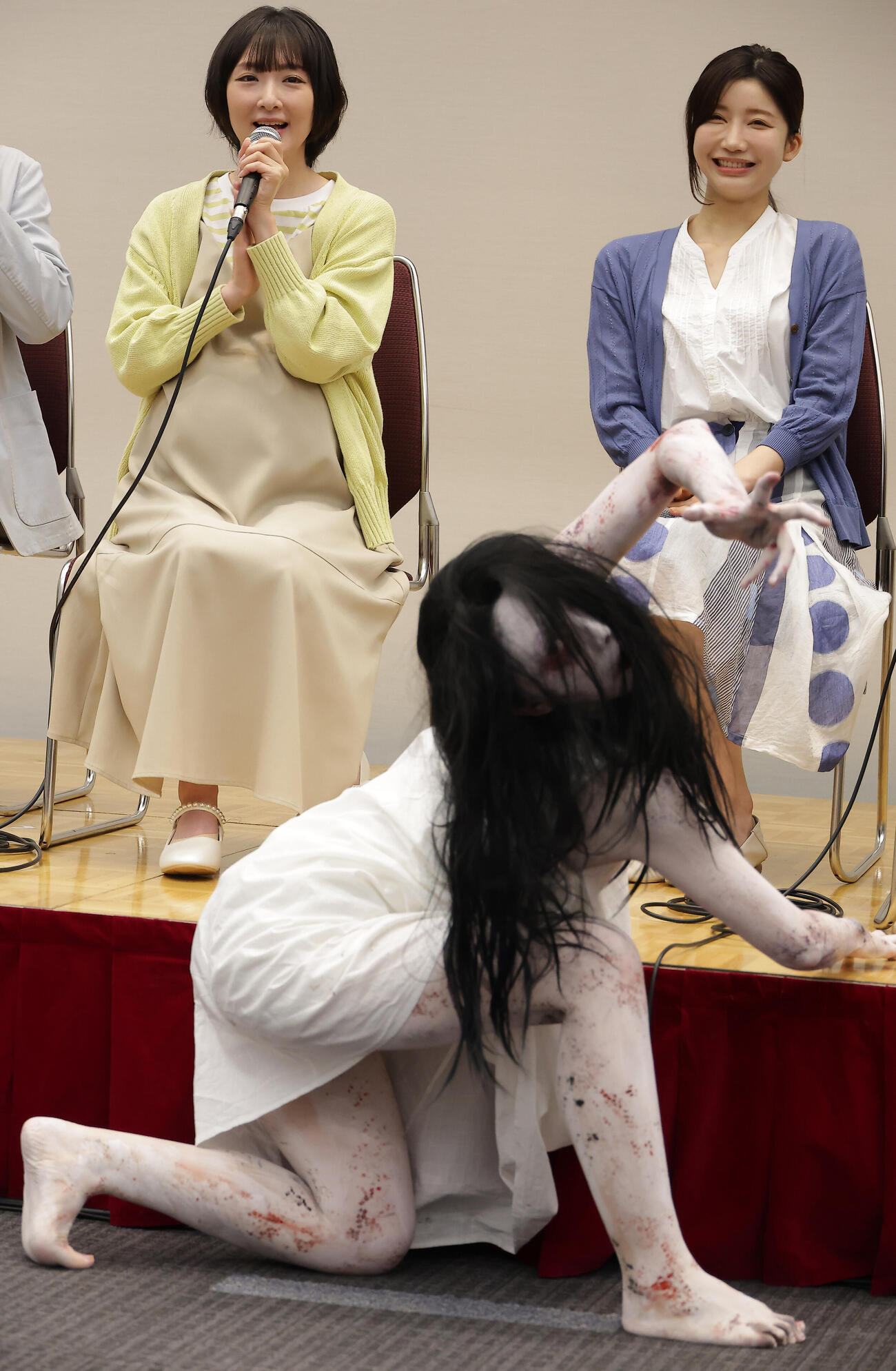舞台「呪怨」製作発表会見でキャラクターの佐伯伽椰子（手前）の登場に興奮気味の生駒里奈（左）と小倉ゆうか（撮影・中島郁夫）.