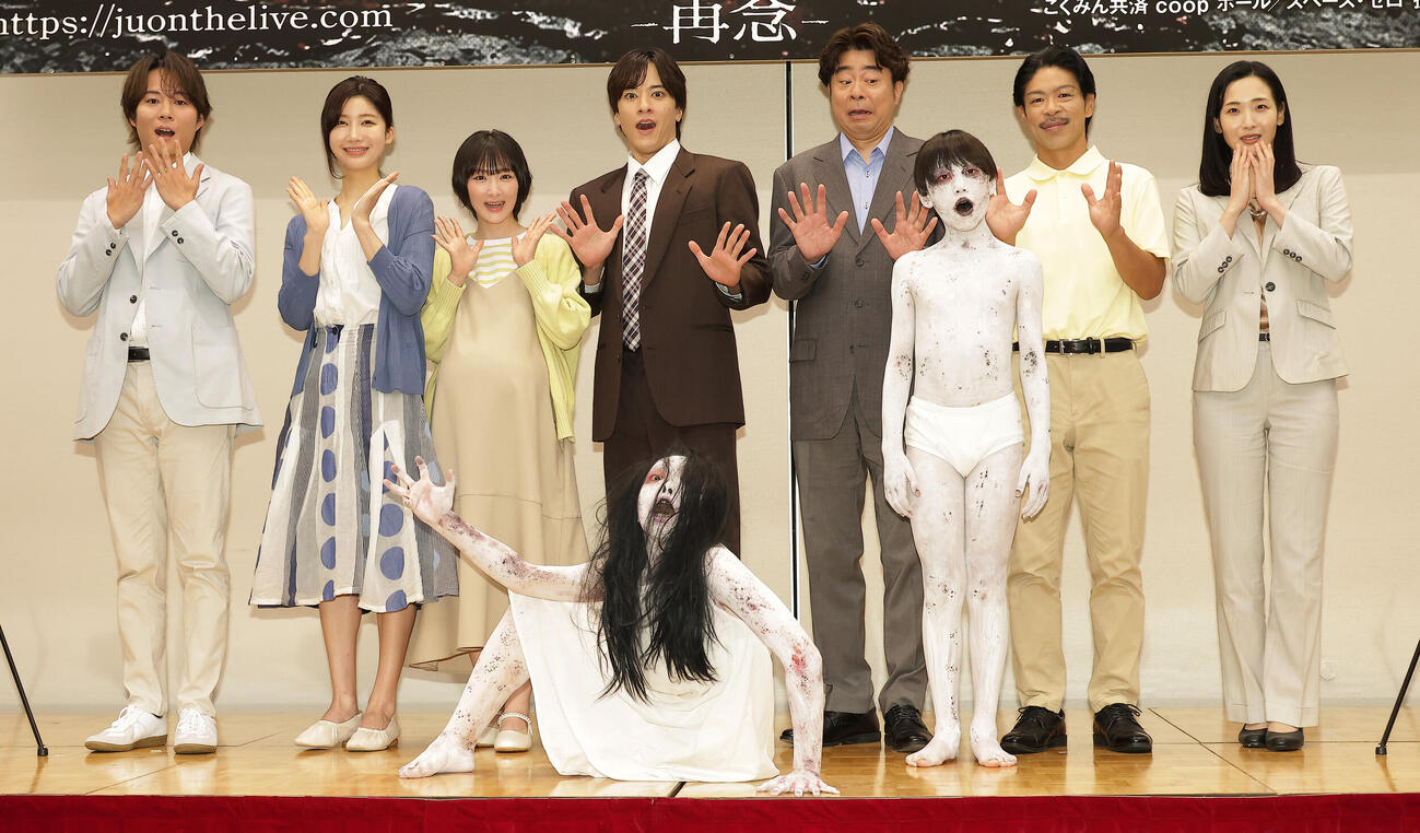 舞台「呪怨」製作発表会見でキャラクターの佐伯伽椰子（手前左）と息子の俊雄（手前右）を迎え記念撮影するキャスト。左から杉本琢弥、小倉ゆうか、生駒里奈、松島庄汰、有野晋哉、松本利夫、蘭乃はな（撮影・中島郁夫）.