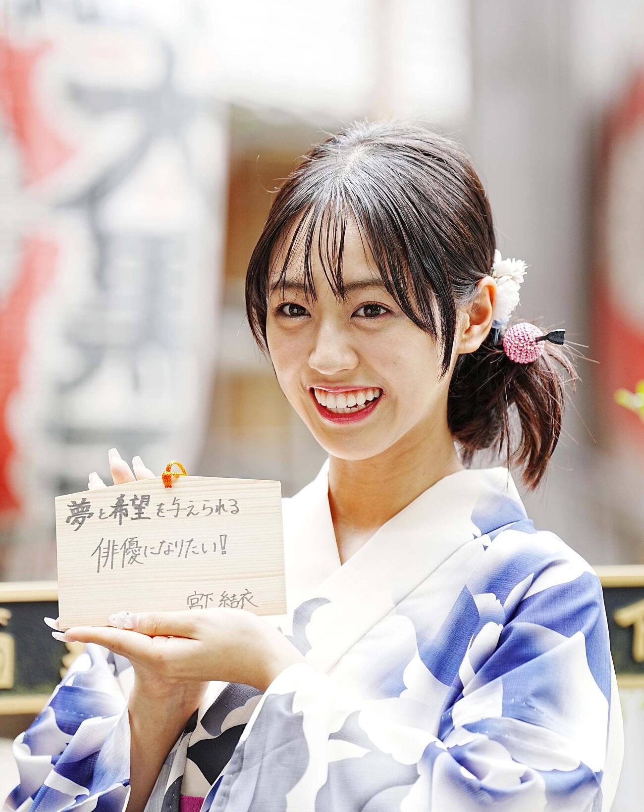 二十歳を迎え絵馬に抱負をしたためる宮下結衣（撮影・小沢裕）
