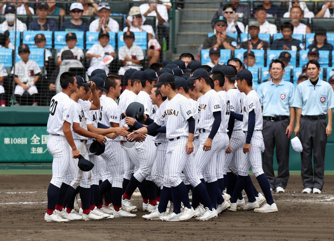 有明対東日本国際大昌平　初出場同士の対決を制してベスト8入りを決めた有明ナイン（左）は、試合後に東日本国際大昌平ナインと握手を交わす