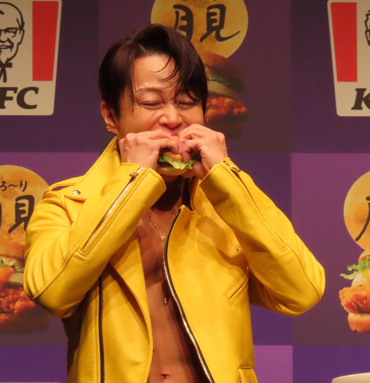 「ケンタッキーフライドチキン『とろ～り月見』新商品発表会」イベントに登壇し、月見バーガーにかぶりつく西川貴教
