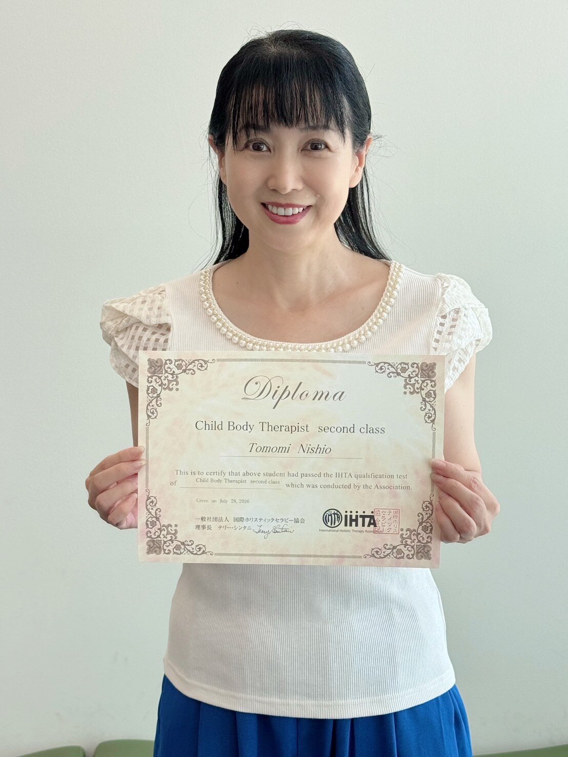チャイルド・ボディ・セラピストのし各認定書を手にする西村知美