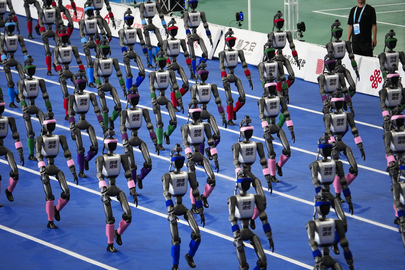 22日、北京での「世界人型ロボットスポーツ大会」開幕式で行進するロボット（共同）
