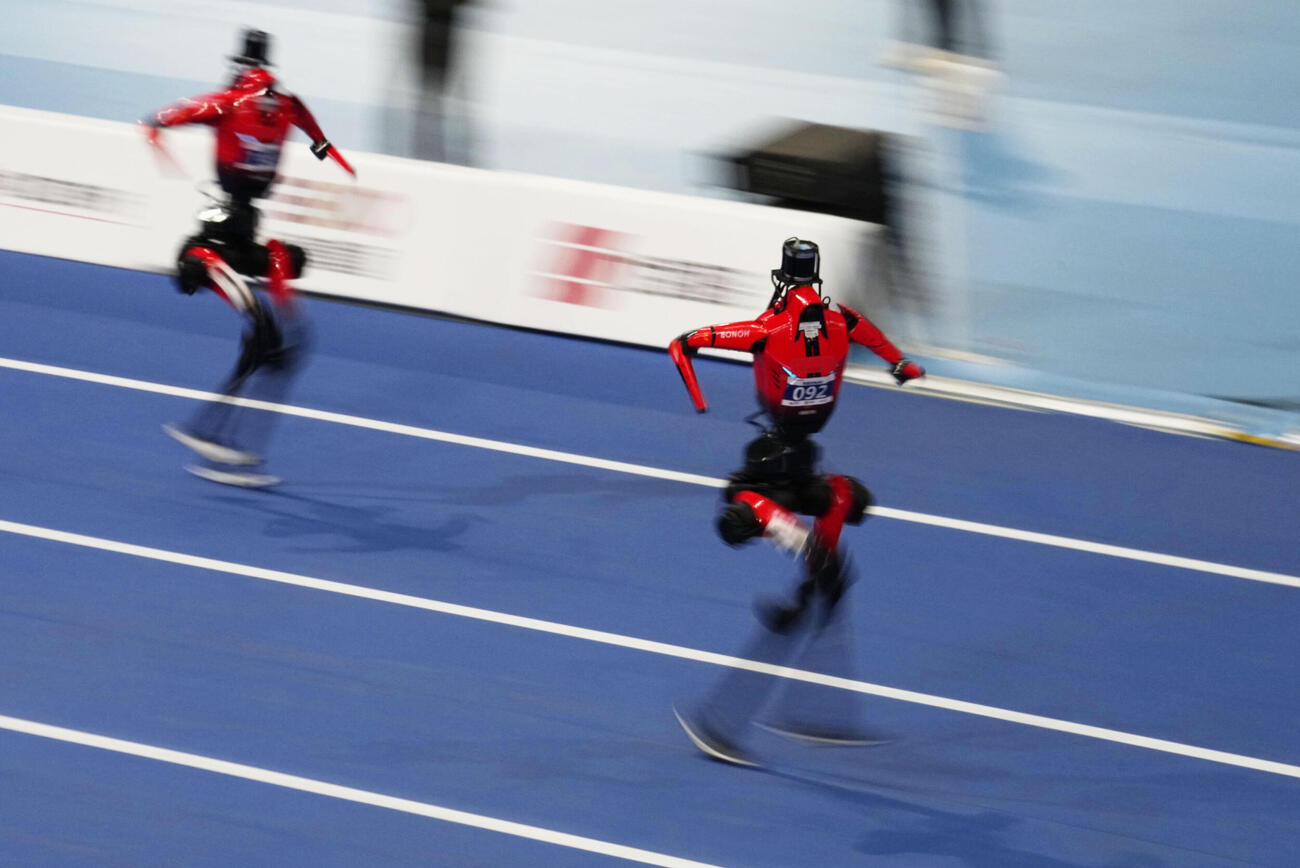 22日、北京での「世界人型ロボットスポーツ大会」の陸上400メートルで走るロボット（共同）