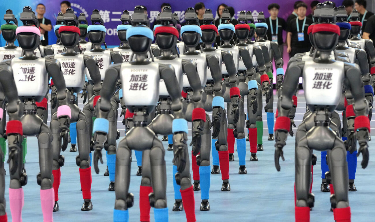 22日、北京での「世界人型ロボットスポーツ大会」の開幕を前に整列するロボット（共同）