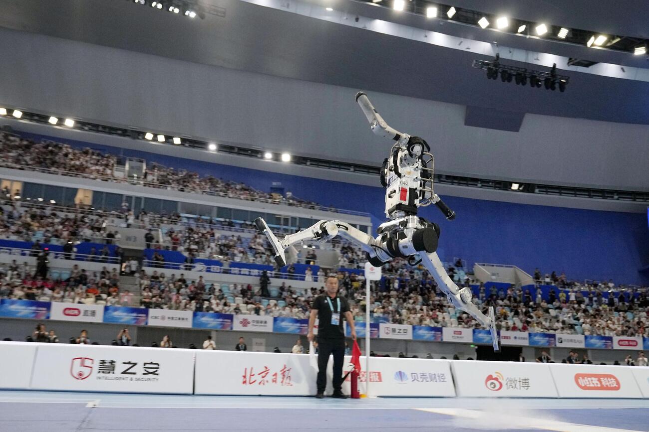 23日、北京での「世界人型ロボットスポーツ大会」の走り幅跳びで跳躍するロボット（共同）