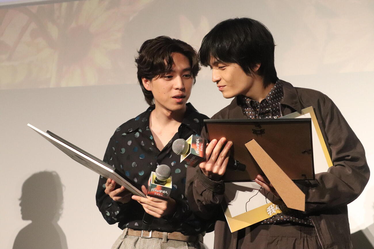映画「我々は宇宙人」ジャパンプレミアで、門脇康平監督からプレゼントされた似顔絵を見せ合う板東龍汰（左）と岡山天音