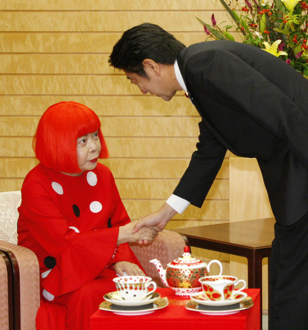 首相官邸で安倍首相（右）と握手する草間弥生さん＝2013年9月（共同）