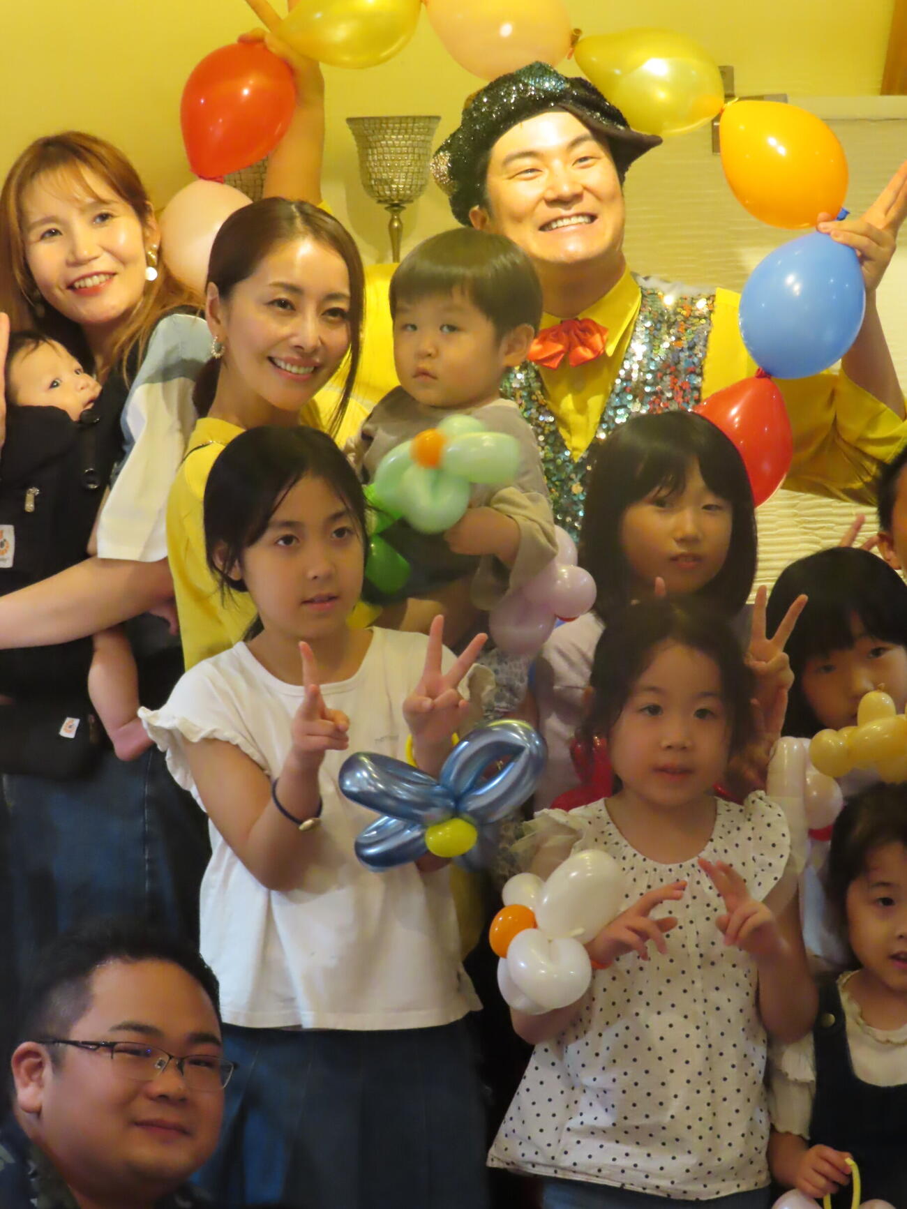 子ども食堂「ピースのごはん」で子供たちに囲まれて笑顔を見せる熊切あさ美（左）とハッピーつつい